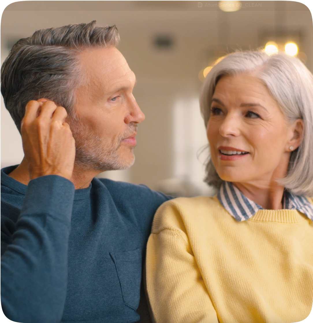 Man and woman sitting close together, possibly in a home setting. 